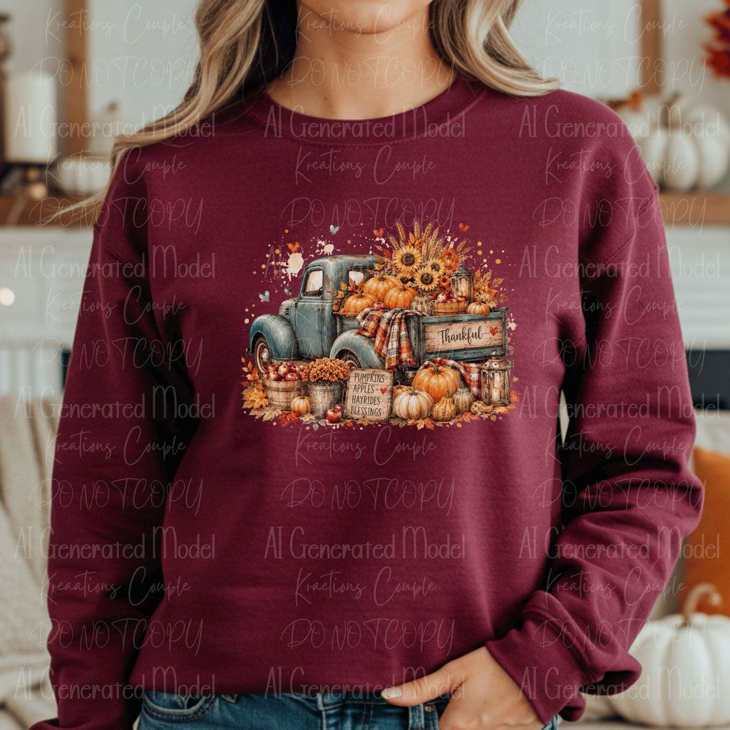 Thankful vintage blue pickup truck filled with pumpkins, sunflowers, apples and autumn harvest on burgundy sweatshirt